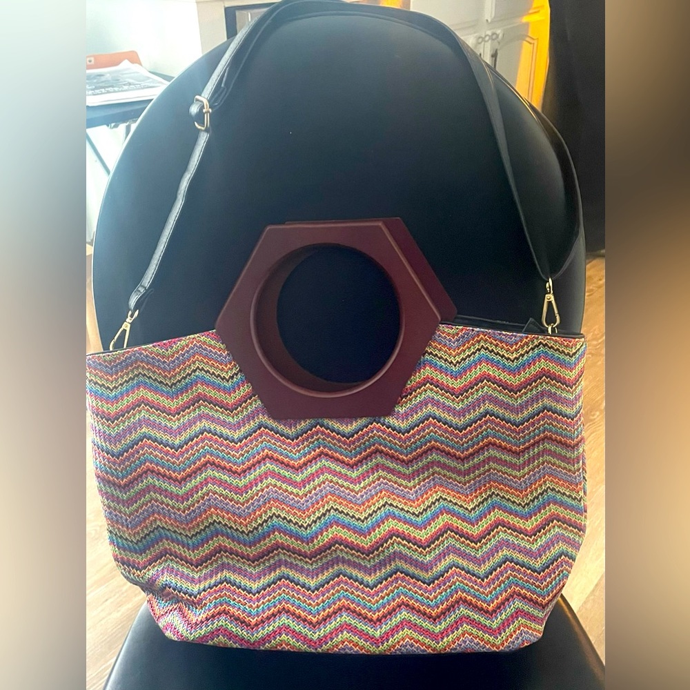 Colorful chevron pattern purse with wooden handle and adjustable shoulder strap.